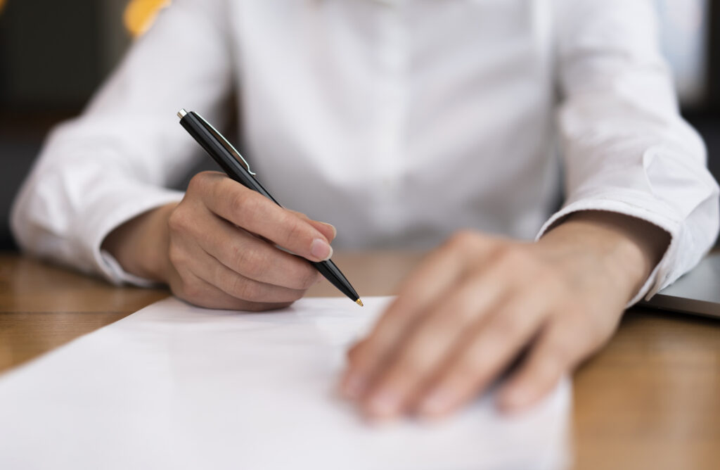 Close up of a person signing a document